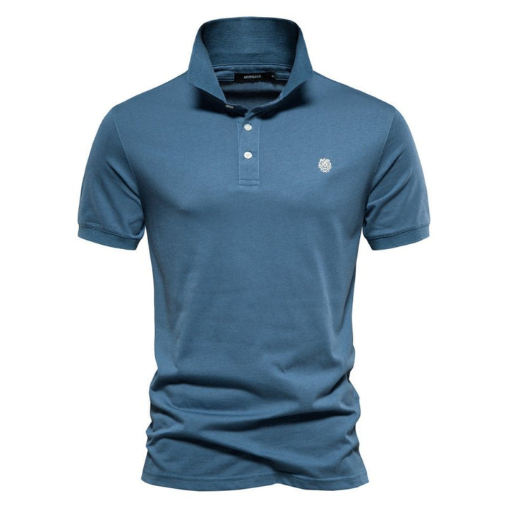 Polo homme bleu acier à coupe ajustée, style intemporel et élégant, avec col classique, patte de boutonnage et logo discret sur la poitrine modèle Wulfric tendance.