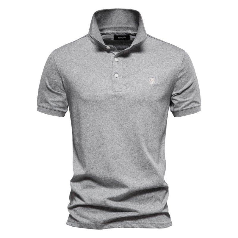 Polo homme gris clair à coupe ajustée, design intemporel et moderne, avec col classique et patte de boutonnage, logo discret sur la poitrine.