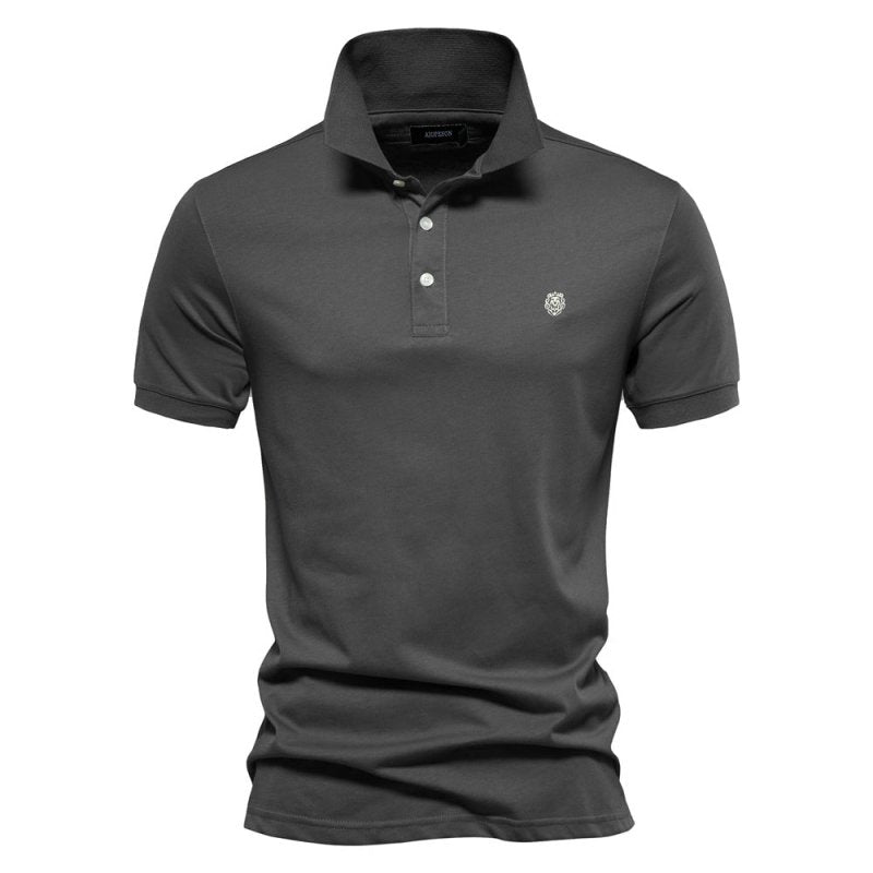 Polo homme gris foncé à coupe ajustée, style intemporel et élégant, avec col classique et boutonnière, logo discret sur la poitrine.