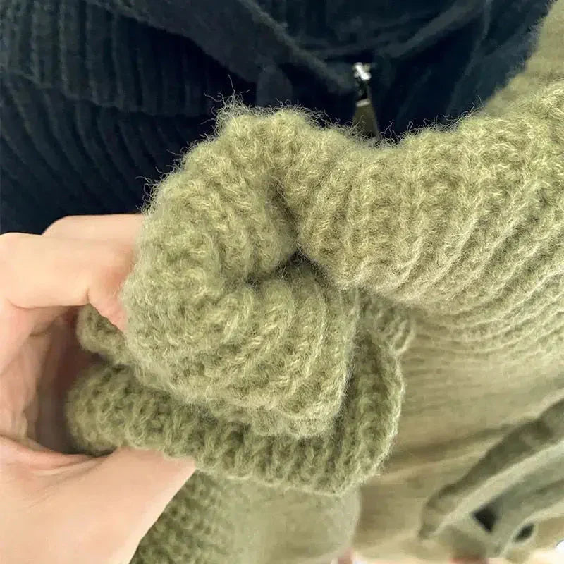 Gros plan sur deux gilets en grosse maille, l'un vert et l'autre beige. L'image met en valeur la douceur de la maille et la qualité du tissu, agréable et chaud au toucher. Une main tient la manche du gilet vert, soulignant sa souplesse et son épaisseur. La photo illustre le savoir-faire méticuleux et le confort de la matière, idéal pour un style à la fois cosy et élégant.