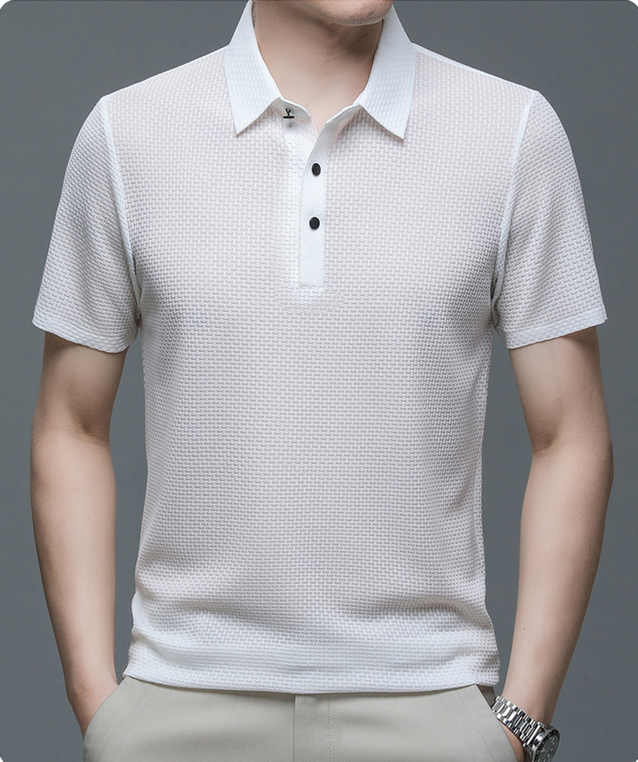 Un polo blanc en maille texturée, avec un col classique et des boutons noirs contrastés. Ce modèle élégant et confortable est idéal pour un look moderne et décontracté, parfait pour toutes les occasions.