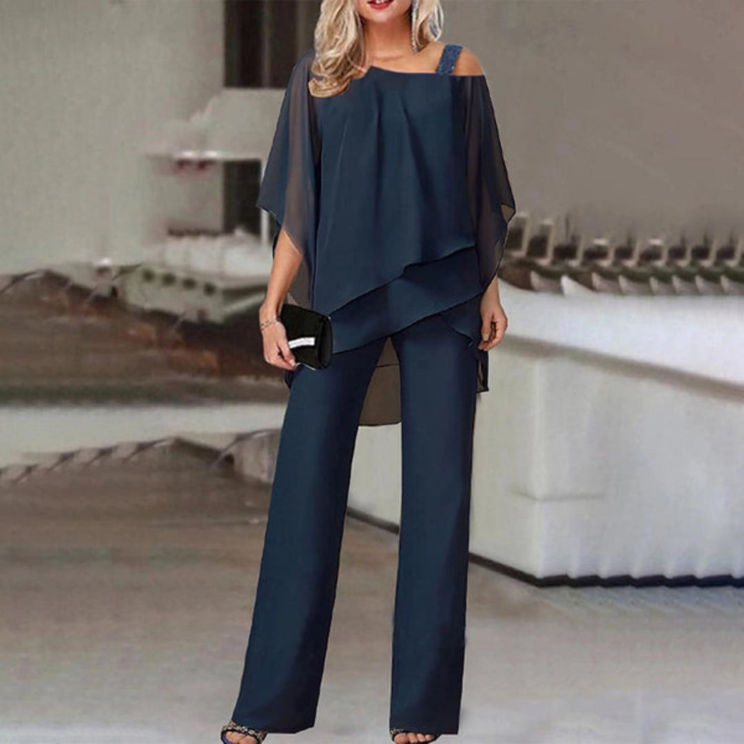 Découvrez l'ensemble Zahra, un duo moderne et tendance pour femme. Ce modèle comprend un haut fluide à manches ouvertes, agrémenté de bretelles à strass, et un pantalon assorti à la coupe élégante. Parfait pour une soirée ou une sortie chic, cet ensemble allie confort et sophistication, tout en vous assurant un look raffiné et intemporel.