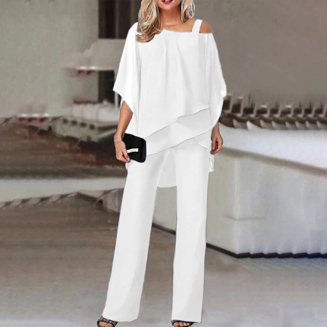 Adoptez un look élégant et moderne avec l'ensemble Zahra en blanc. Ce duo tendance comprend un haut fluide à manches ouvertes et des bretelles décorées de strass, accompagné d'un pantalon large pour une silhouette chic et raffinée. Idéal pour une soirée ou une occasion spéciale, cet ensemble allie confort et sophistication.