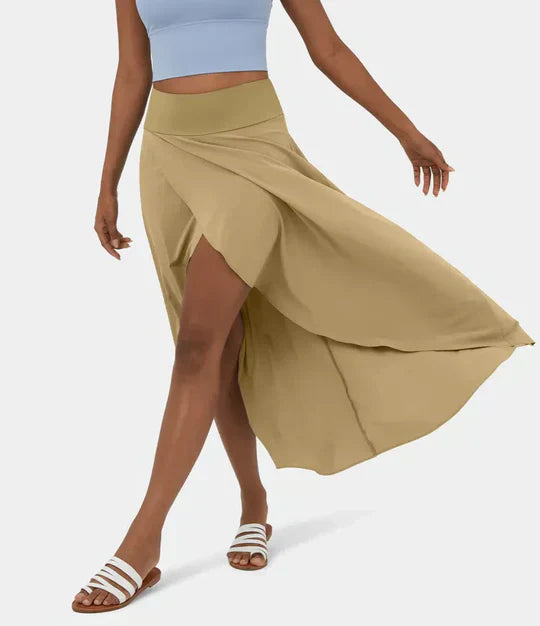 Jupe fluide et légère en coloris beige, avec une coupe asymétrique et une fente élégante sur le côté. Idéale pour un look estival chic et décontracté, portée avec un top court et des sandales.
