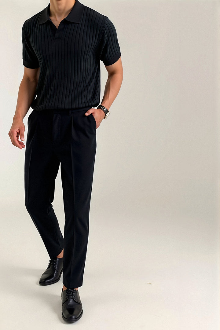 Polo homme noir à manches courtes, avec un motif côtelé vertical, porté avec un pantalon noir élégant pour un look moderne et raffiné. Ce modèle au col classique et à la coupe ajustée offre une silhouette chic et décontractée, idéale pour des occasions formelles ou pour un style quotidien sophistiqué.