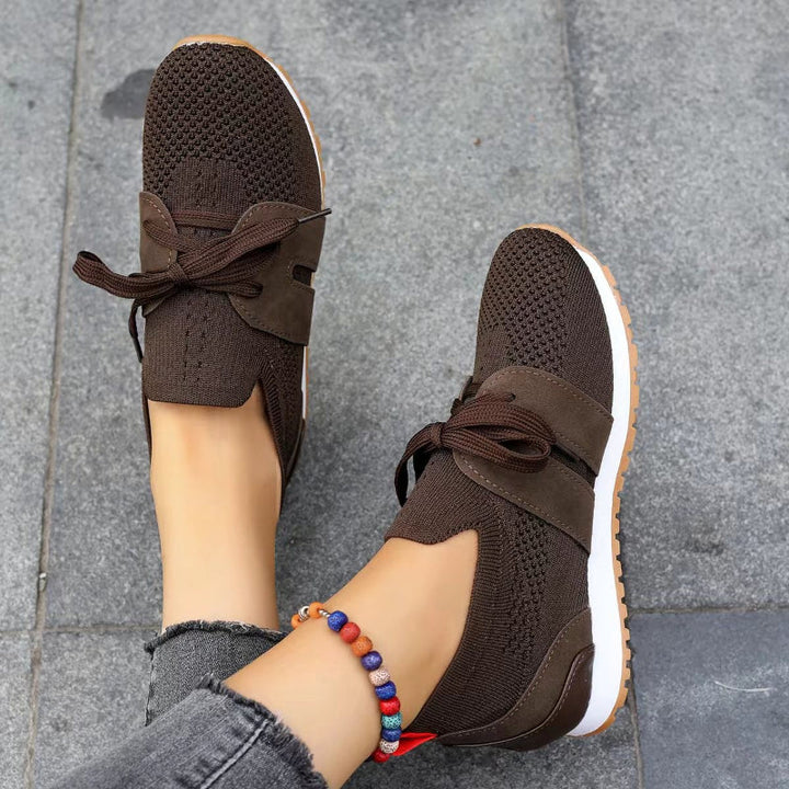 Baskets femme marron en maille respirante avec lacets, empiècements suédés, semelle plate blanche et extérieure gomme, look moderne et confortable.