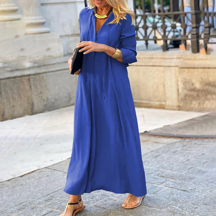 Robe maxi d'été pour femme Zoraida, moderne et élégante, dans une magnifique teinte bleue. Cette robe longue et fluide, parfaite pour les journées estivales, allie confort et style. Accessoirisée avec des bijoux dorés et des sandales, elle offre un look chic et décontracté.